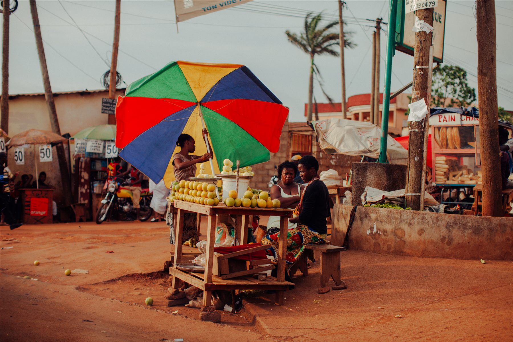Street vendor beneath a multicoloured umbrella