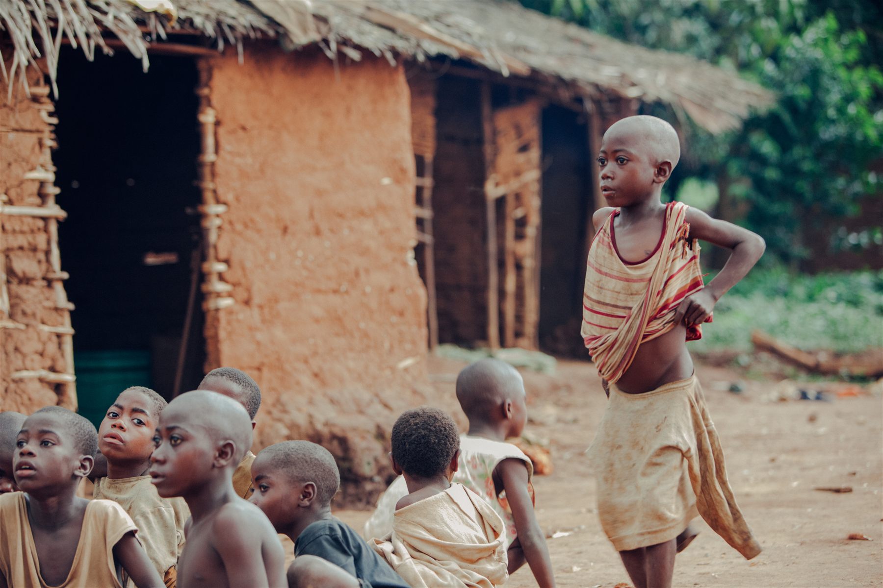 Children seated beside a building